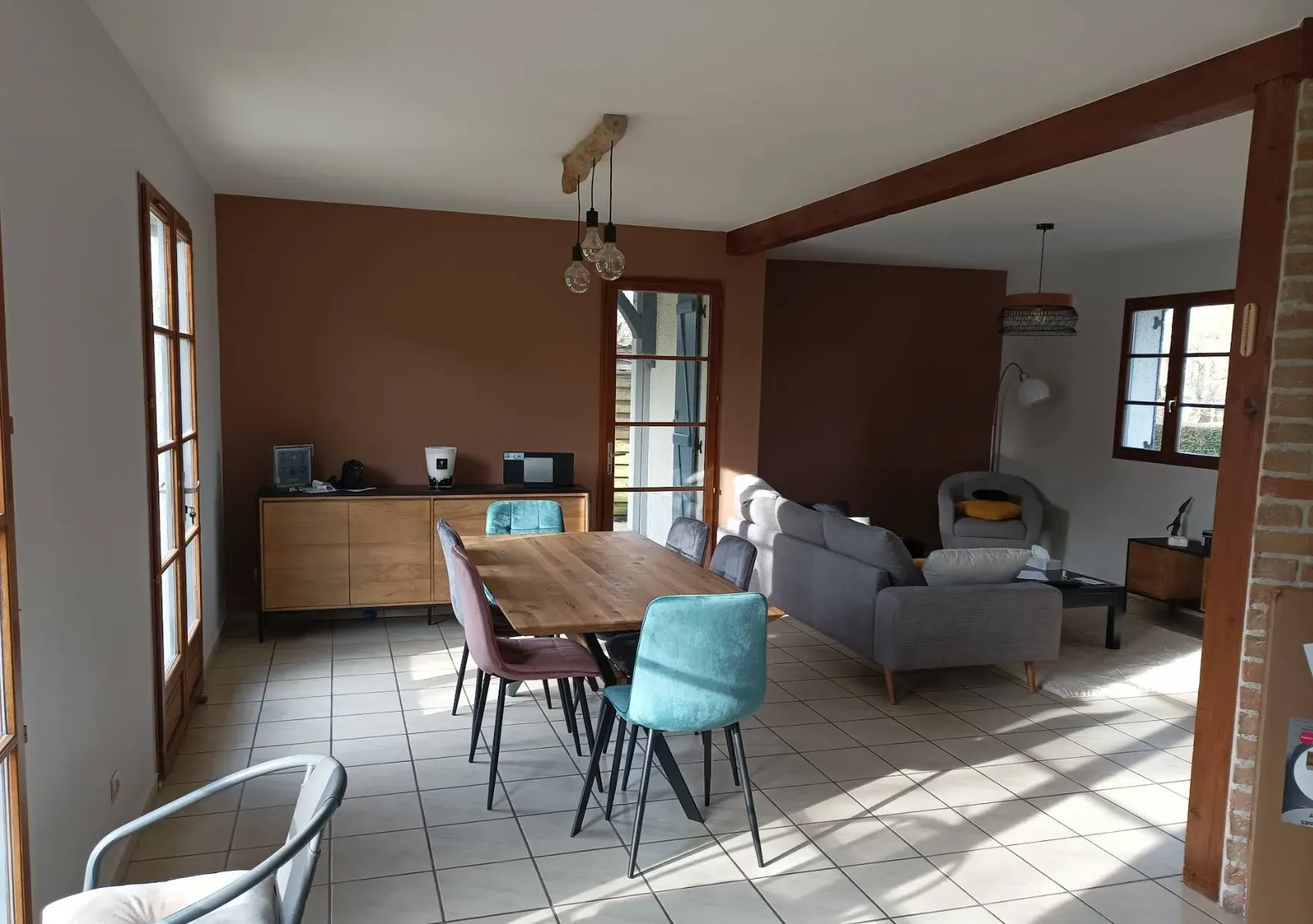 Salon ouvert avec mur en briques et poutre apparente