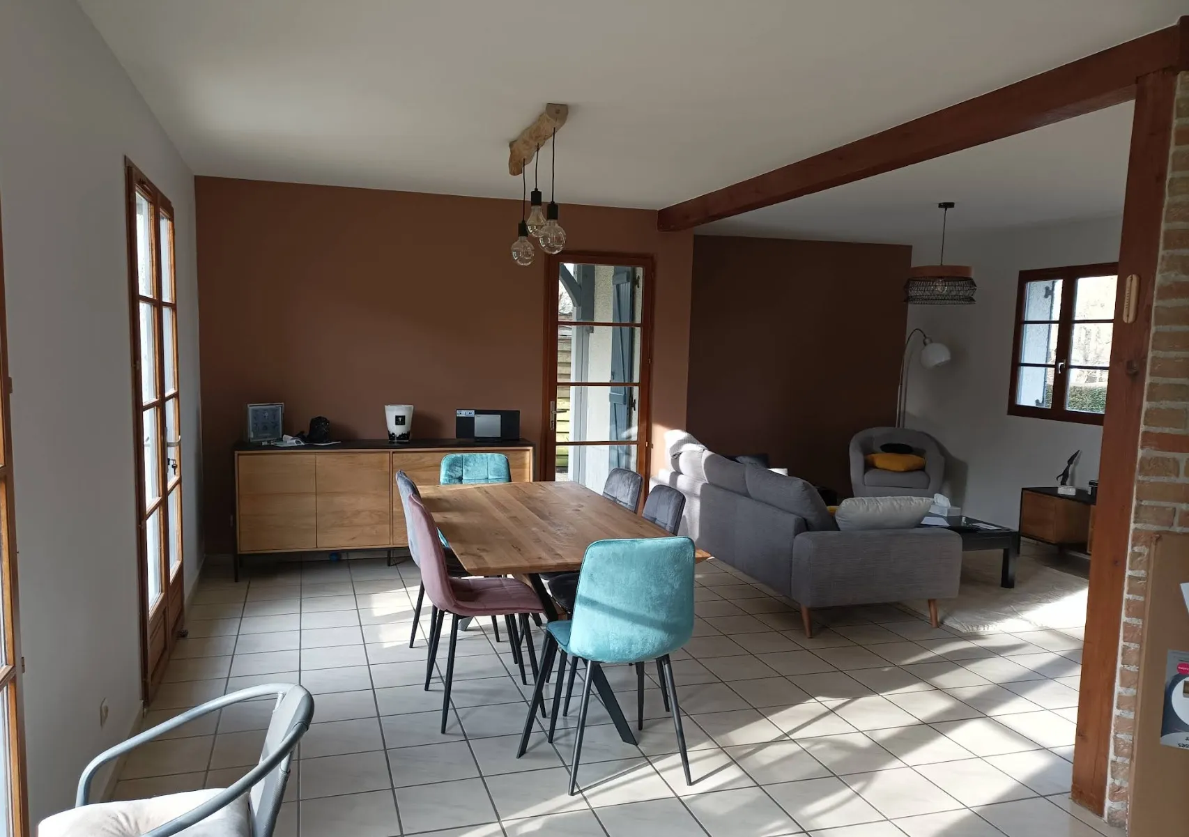 Salon ouvert avec mur en briques et poutre apparente